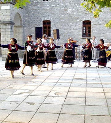 Γυναίκες παραδοσιακά ντυμένες χορεύουν στο πανηγύρι.
